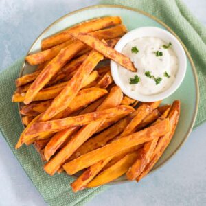 Sweet and crispy baked sweet potato fries with dipping sauce on side