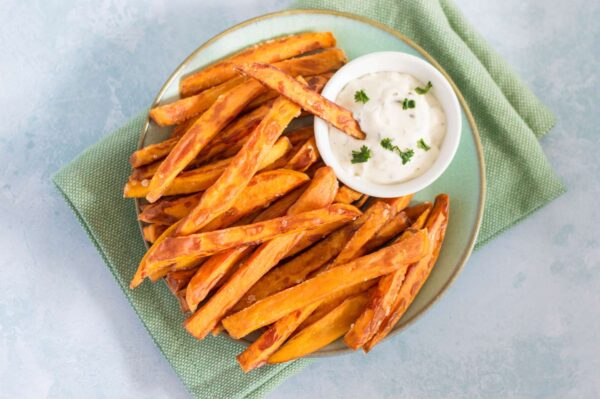 Sweet and crispy baked sweet potato fries with dipping sauce on side